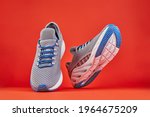 Stability and cushion running shoes. New unbranded running sneaker or trainer on orange background. Men's sport footwear. Pair of sport shoes.