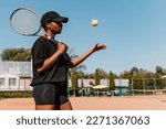 African american woman hold racket and yellow green ball, playing tennis match on clay court surface on weekend free time sunny day. Female player ready to serve. Professional sport concept
