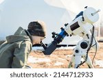 Small photo of Child boy watching the sun through a telescope on a tripod at the observatory for observation of stars and planets. Science, astronomy concept