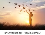 Woman praying and free bird enjoying nature on sunset background, hope concept