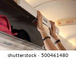 close up of hand open overhead locker on airplane