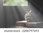 Hand folded in prayer to god on Holy Bible book in church concept for faith, spirituality and religion, woman person praying on holy bible in morning. christian catholic woman hand with Bible worship.
