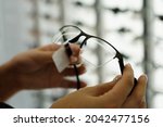 Woman hand holding the eyeglasses in optics store, close up