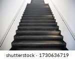 Staircase with black stone steps and steel handrails. Abstract modern architecture or interior background in concept of ascent or moving up.