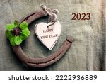Horseshoe four leaf clover heart with  text in english  Happy New Year and number 2023