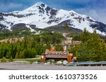 Small photo of Big Sky Montana, United States- June 21, 2011: Welcome to Big Sky Mountain Village Signage, dwarfed by the enormity of Lone Mountain full of snow in the Madison Range in the state of Montana USA.