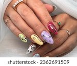 Female hands with a multiple color nail art close-up. Nail design. Artistic manicure with a multiple nail polish
