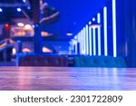 Small photo of Selective focus on the table board of a restaurant nightclub modern design background in neon blue light.