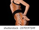 Small photo of Thin young girl in leopard pattern suit posing and seducing, attracting attention with her hand on a black background.
