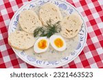 Top view on the rustic vintage blue onion porcelain plate with traditional Czech bread dumplings in dill sauce and boiled egg. Fresh, healthy, seasonal example of traditional recipe of Czech cuisine.