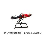 Man doing exercise on inversion table for his back pain, isolated on white