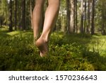 Barefoot woman walking in forest