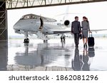 Businesswoman and Businessman walking towards a private jet