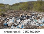 Small photo of A view of the landfill. Garbage dump. A pile of plastic rubbish, food waste and other rubbish. Pollution concept. A sea of garbage starts to invade and destroy a beautiful countryside scenery.
