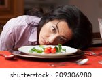 Woman looking to a little salad is tired about diet.