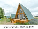 Small photo of A country complex of several triangular guest houses with panoramic glazing . Country recreation in nature in an eco-hotel . Country house .