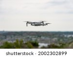Drone in flight, hovering, with visible propellers in movement. Photo and video shooting from the sky. Blurred background with copy space and place for space.