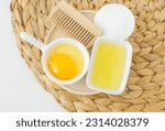 Small bowls with raw egg and olive oil. Homemade hair or face mask, natural beauty treatment and spa recipe. Top view, copy space.