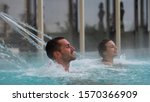 Small photo of An young couple is enjoying and having relax in a whirlpool bath tube in a luxury wellness center.