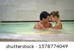 Small photo of An young couple is embracing and having relax in a whirlpool bath tube in a luxury wellness center.