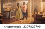 Small photo of Young Couple Dancing and Having Fun in the Kitchen: Enjoying Each Other's Company and Playfully Moving to Music. With Joyful Laughter and Smiles, they Embrace the Music and Dance