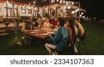 Small photo of Big Indian Family Celebrating Diwali: Family Gathered Together on a Dinner Table in a Backyard Garden Full of Lights. Group of Adults Sharing Food, Laughs and Stories on a Hindu Holiday