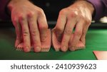 Small photo of Close Up On Hands Of Professional Poker Dealer Doing A Riffle Shuffle Of Playing Cards Before High Stakes Game In Luxurious Casino. Anonymous Croupier Shuffling Deck Before Tournament