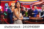 Small photo of Advertising Campaign Portrait of a Sophisticated Asian Woman in a Stunning Dress Posing and Looking at Camera in a Glamorous Casino with Hustlers and Gamblers Playing Roulette in Vibrant Background