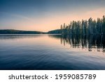 Forest lake in Sweden on a spring late afternoon, after sunset. Bredsjön lake in Stjärnfors under a blue-pink soothing sky. Relaxing nature image. Explore Scandinavia. 