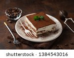 Tiramisu. Traditional italian dessert on white plate, wooden background. Selective focus