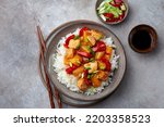 Sweet ad sour chicken with steamed rice, top view