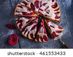 Small photo of rustic plum cake on dark background , top view