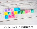 Small photo of "World cease fire day "-the words on wooden cubes. A background image of english words on colorful building blocks.