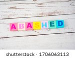 Small photo of "abashed"-the words on wooden cubes. A background image of english words on colorful building blocks.