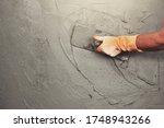 hand of worker plastering cement at wall for building house