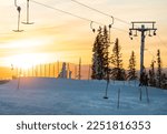 Åre ski center during sunset. Skilifts taking people up the hill. Amazing sunset during sking and snowboarding holiday.  Perfect weather to enjoy the winter holiday in Skandinavia