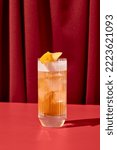 Small photo of Classic cocktail whiskey sour with egg foam in highball glass on red background. Whiskey sour on coloured background in trendy style. Contemporary concept with alcohol beverage with shadow