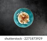 Small photo of Fancy appetizer of grilled sea scallops in creamy sauce. Roasted sea scallops in cheese espuma in ceramic bowl on black concrete background. Seafood menu. Delicatessen sea scallop on dark stone table