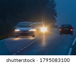 Small photo of Car with incorrectly adjusted headlights starts to overtake motion blur