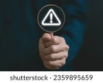 Small photo of Businessman using laptop showing warning triangle and exclamation sign icon Warning of dangerous problems Server error. Virus. Maintenance concept. caution internet technology network security
