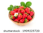 fresh juicy strawberries with leaves in a wooden basket on white background.