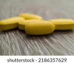 Small photo of Amantadine yellow pill medication used to treat dyskinesia associated with parkinsonism and influenza caused by type A influenzavirus drug with widespread drug resistance