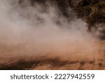 A dust storm. Powdered dust and sand flowing into air on a gravel road. Concept of extreme weather events, rally and offroad races. Copy space.
