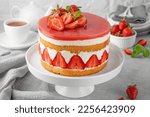 Fraisier mousse cake. Strawberry cake with sponge cake, mousse and jelly on a gray concrete background. Summer dessert. Selective focus. Copy space.