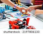 Small photo of Defocus children hands holding ready made robots on table Joyful smart whizzkid experimenting with humanoid robotic hand while developing his skills. Coding school. Out of focus.