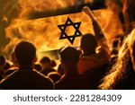 Protests Israel Tel Aviv. Israel flag. Protest in Israel 2023. Rise hand. Defense minister. Fire, flame, revolution. Out of focus.