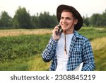 Small photo of Young smiling farmer talking on the phone. The agricultural business plays a vital role in providing food, fiber, and other resources to meet the needs of a growing population and economic viability.