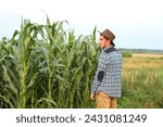 Small photo of Caucasian calm male maize grower in walks along corn field. Copy space. Caucasian male maize grower calmly walking through a corn field.
