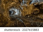 Small photo of In the cave of the old tunnel. Mineshaft cave. Cave in mines. Rails in mineshaft cave
