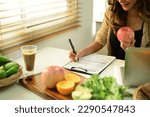 Nutritionist sitting at desk with fruit and vegetable, working on diet plan. Healthy eating, right nutrition and diet concept